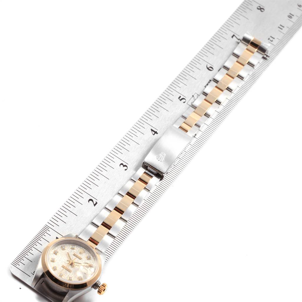 The image shows a Rolex Datejust 69163 Women
s Steel and Gold (two tone) Silver Dial 69163 Women
s Steel and Gold (two tone) Silver Dial watch positioned flat next to a ruler, highlighting its face and metal bracelet with clasp.
