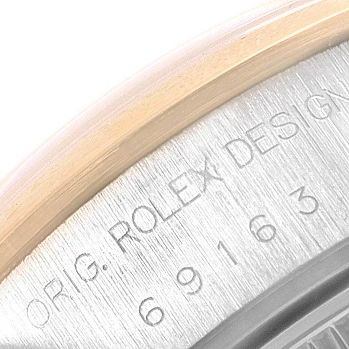 The image shows a close-up of the side of a Rolex Datejust 69163 Women
s Steel and Gold (two tone) Silver Dial 69163 Women
s Steel and Gold (two tone) Silver Dial watch, highlighting the engraved text and serial number on the case.