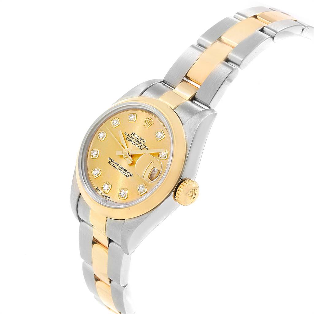 The image shows a Rolex Datejust 79163 Women's Steel and Gold (two tone) Champagne Dial 79163 Women's Steel and Gold (two tone) Champagne Dial model, highlighting its gold and silver bracelet, gold dial, and diamond markers from an angled view.