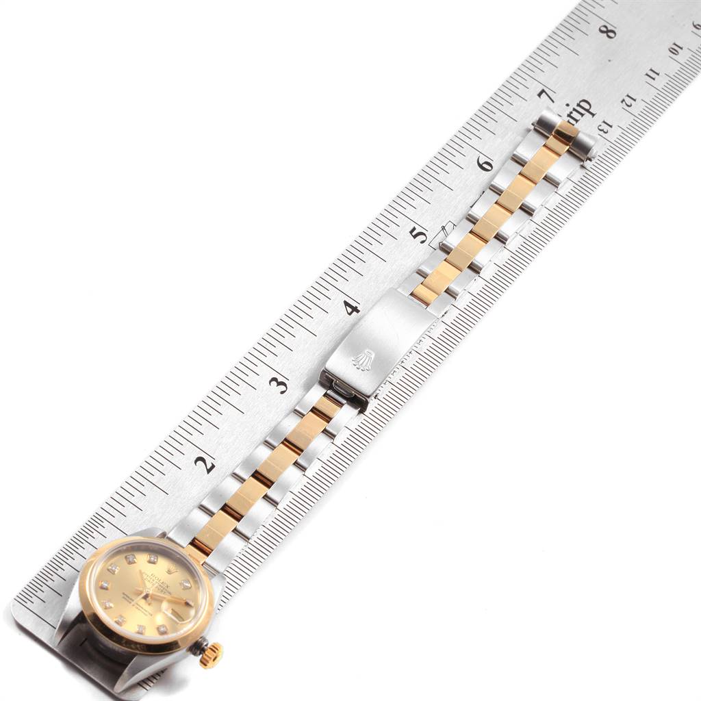 The image shows a Rolex Datejust 79163 Women's Steel and Gold (two tone) Champagne Dial 79163 Women's Steel and Gold (two tone) Champagne Dial watch with a ruler, highlighting the gold dial, and two-tone bracelet with clasp.