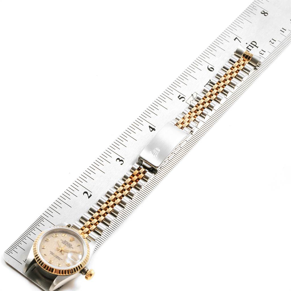 The image shows a Rolex Datejust 69173 Women's Stainless Steel Beige Dial 69173 Women's Stainless Steel Beige Dial watch with a ruler, highlighting its clasp and bracelet.