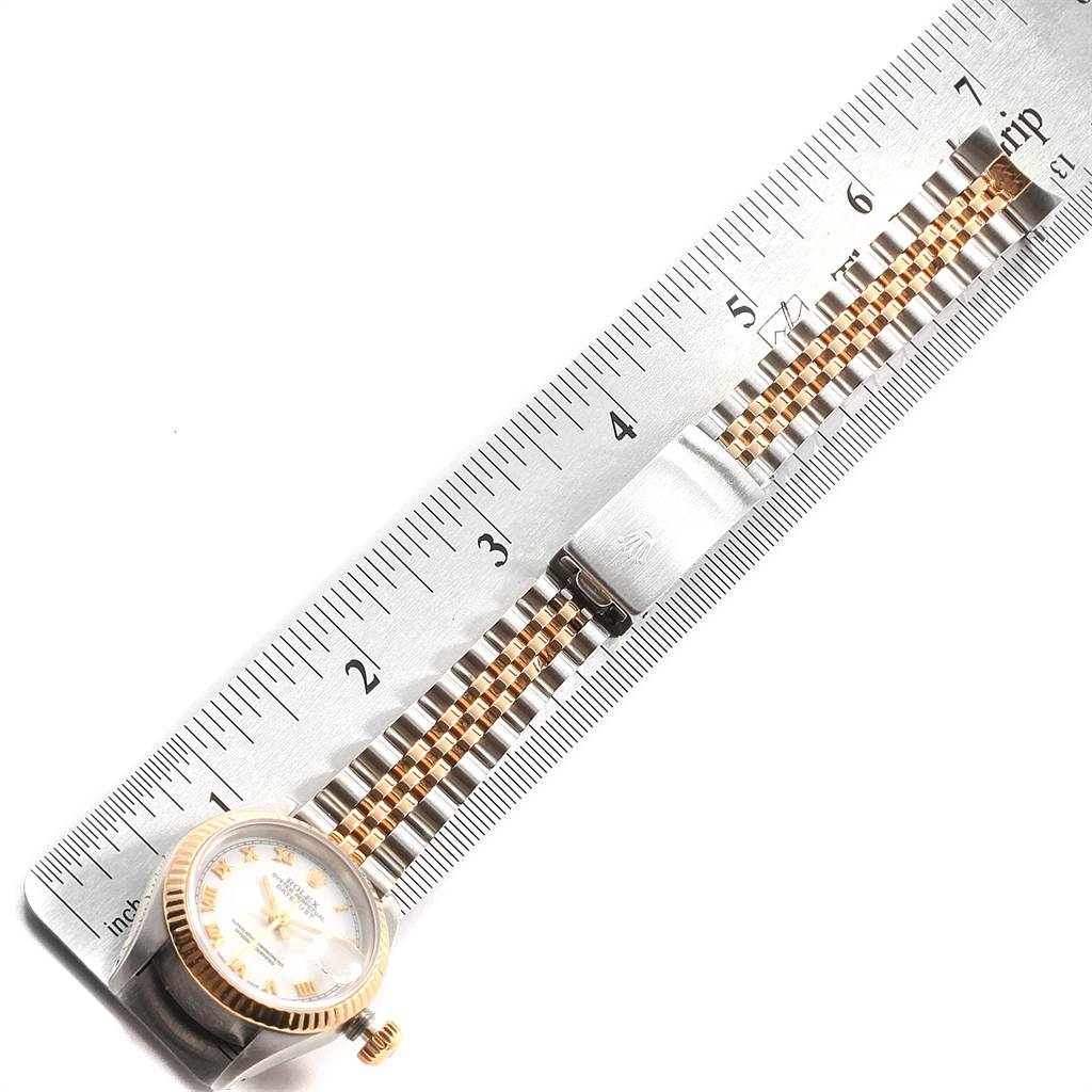 The image shows a Rolex Datejust 69173 Women's Stainless Steel White Dial 69173 Women's Stainless Steel White Dial watch placed horizontally against a ruler, highlighting the face, crown, and bracelet.