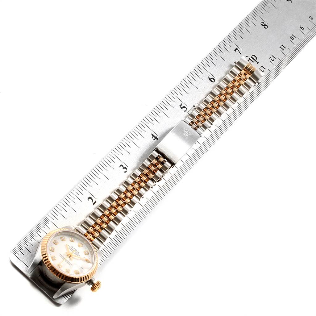 The Datejust model by Rolex is shown from a top view, highlighting its watch face and bracelet alongside a ruler for scale.