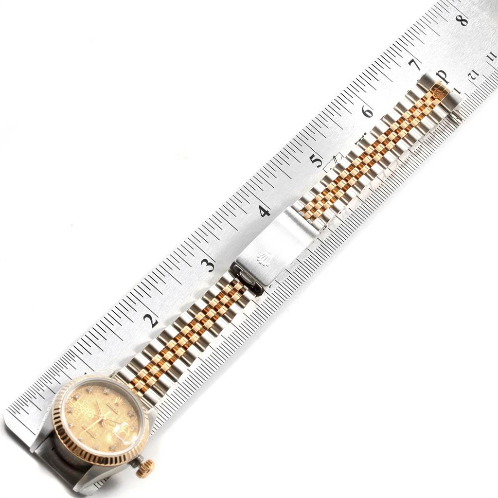 This image shows a Rolex Datejust 69173 Women's Stainless Steel Champagne Dial 69173 Women's Stainless Steel Champagne Dial watch with its watch band extended measured against a ruler, highlighting the watch's face, crown, and segment of the band.