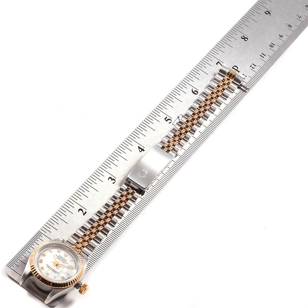 This image shows the Rolex Datejust 69173 Women's Stainless Steel White Dial 69173 Women's Stainless Steel White Dial watch face and band in a top-down view, next to a ruler for scale.