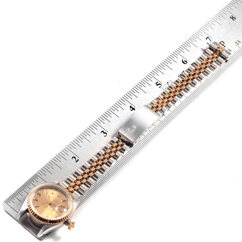 The Rolex Datejust 69173 Women's Stainless Steel Champagne Dial 69173 Women's Stainless Steel Champagne Dial watch is shown from a top-down angle, featuring the face, bezel, and bracelet, positioned next to a ruler.