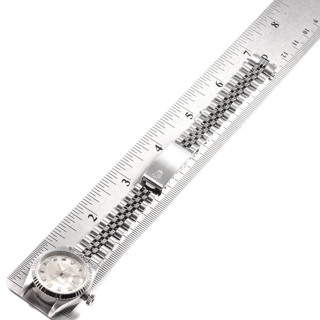 This image shows a Rolex Datejust 69174 Women's Stainless Steel Silver Dial 69174 Women's Stainless Steel Silver Dial watch positioned alongside a ruler, displaying its face and bracelet prominently.