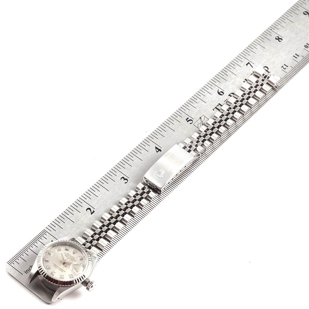 The image displays a Rolex Datejust 69174 Women's Stainless Steel Silver Dial 69174 Women's Stainless Steel Silver Dial watch laid flat along a ruler, showcasing the watch face, band, and clasp.
