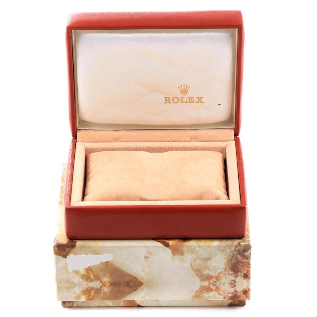 The image shows an open red Rolex watch box for the Datejust model, including a beige cushion inside.