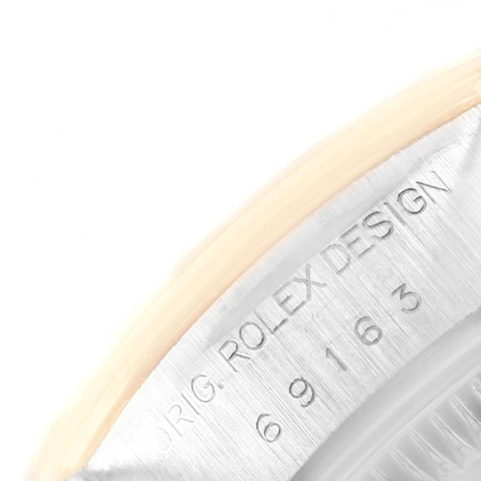 This is a close-up of the engraved serial number and "ORIG. ROLEX DESIGN" on the bezel of a Rolex Datejust 69163 Women's Steel and Gold (two tone) Grey Dial 69163 Women's Steel and Gold (two tone) Grey Dial watch.