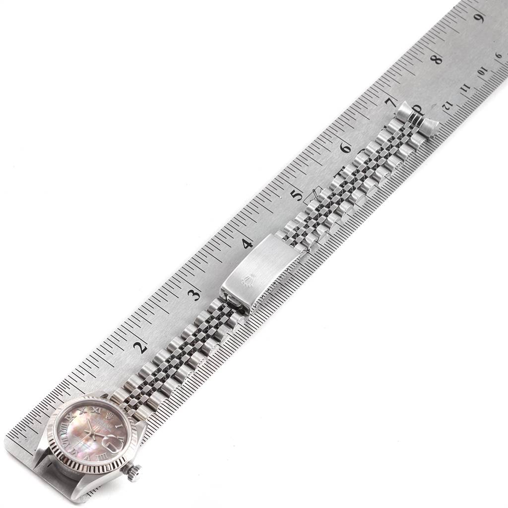 The image shows a Rolex Datejust 79174 Women's Stainless Steel Mother of Pearl Dial 79174 Women's Stainless Steel Mother of Pearl Dial watch placed next to a ruler, displaying its face, crown, and bracelet from a top-down angle.