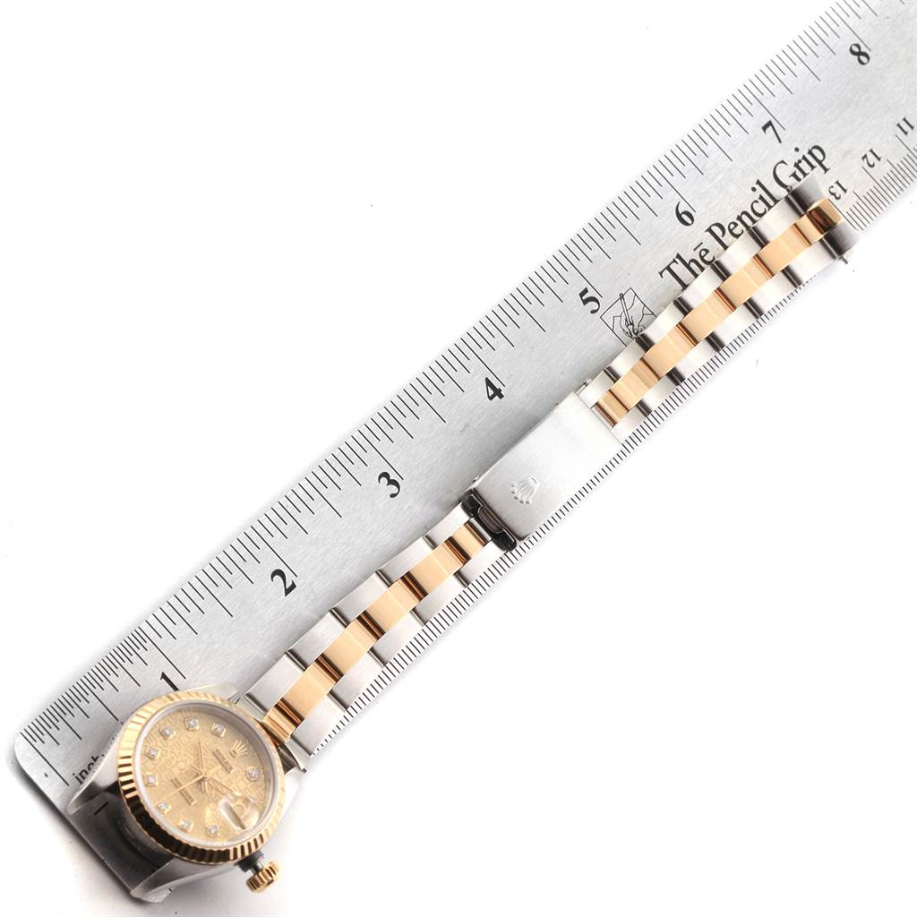 Top view of a Rolex Datejust 79173 Women's Stainless Steel Champagne Dial 79173 Women's Stainless Steel Champagne Dial watch with a two-tone bracelet and the face positioned next to a ruler for measurement.