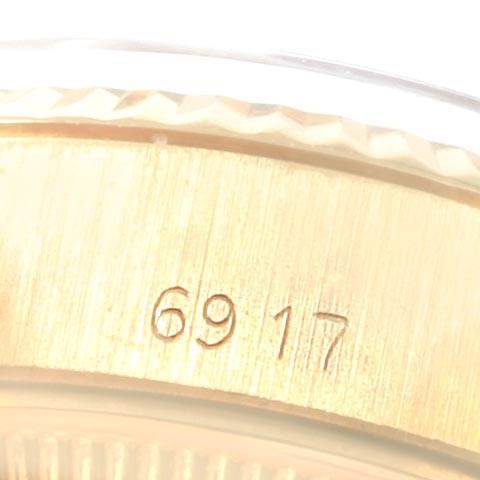 The image shows a macro view of the side of the Rolex Datejust 6917 Women's Yellow Gold White Dial 6917 Women's Yellow Gold White Dial watch, highlighting a part of its gold casing and the engraved number "6917."