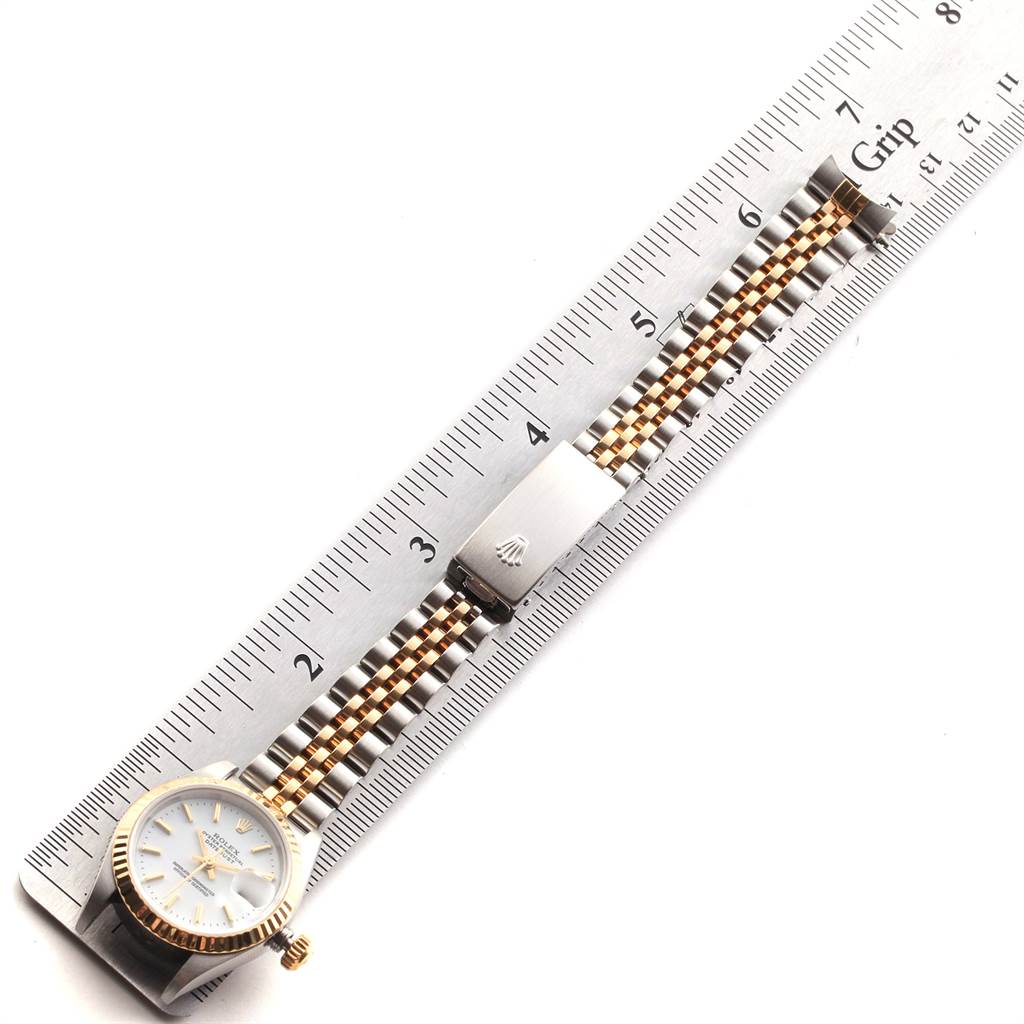 The image shows a top view of a Rolex Datejust 79173 Women's Steel and Gold (two tone) White Dial 79173 Women's Steel and Gold (two tone) White Dial watch, emphasizing the face, crown, and two-tone bracelet beside a ruler.