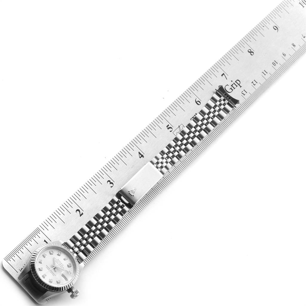 This image shows a Rolex Datejust 69174 Women's Stainless Steel Silver Dial 69174 Women's Stainless Steel Silver Dial watch laid flat against a ruler, highlighting the watch's face, crown, and partially extended bracelet.