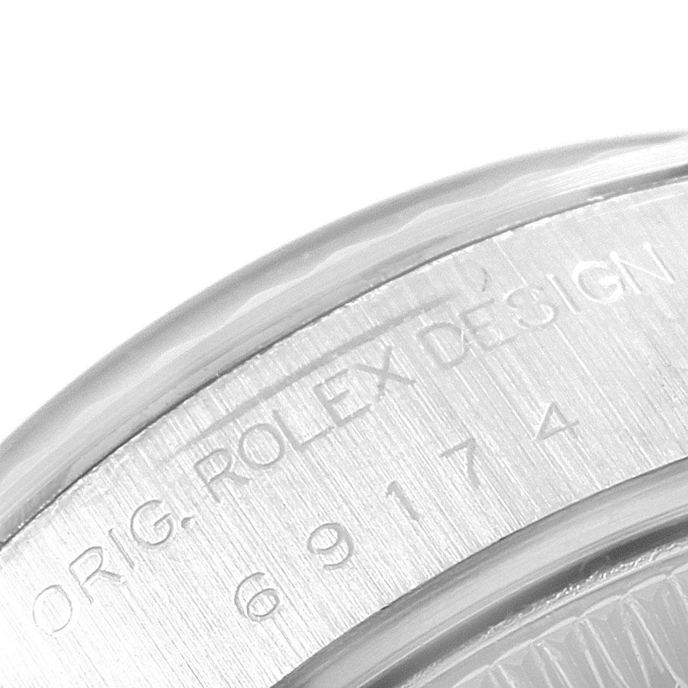 This image shows a close-up of the engraved serial number and design text on the case of a Rolex Datejust 69174 Women's Stainless Steel Silver Dial 69174 Women's Stainless Steel Silver Dial watch.