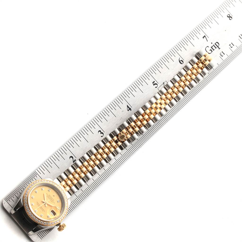 The image shows a top-down view of a Rolex Datejust 179383 Women's Steel and Gold (two tone) Champagne Dial 179383 Women's Steel and Gold (two tone) Champagne Dial watch with part of the bracelet and a ruler for scale.
