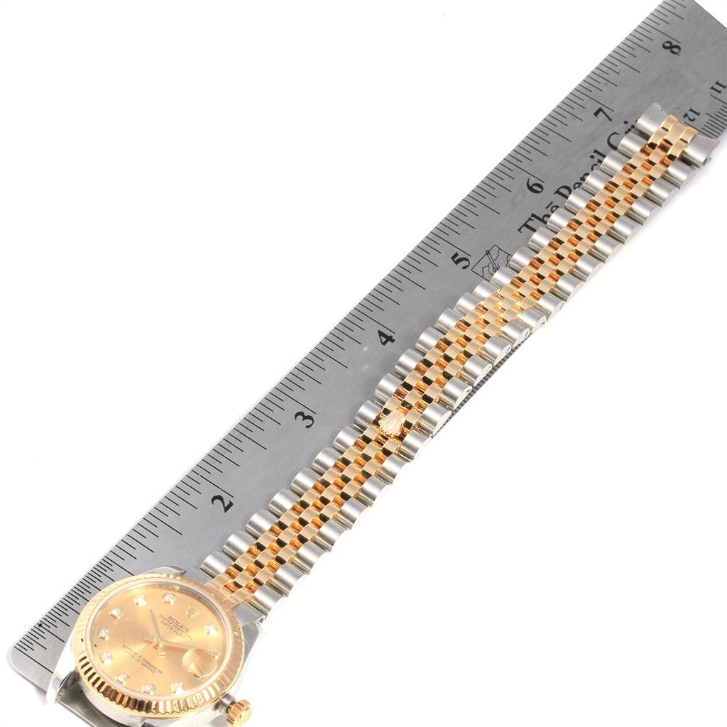 The image shows a Rolex Datejust 178273 Women
s Steel and Gold (two tone) Champagne Dial 178273 Women
s Steel and Gold (two tone) Champagne Dial watch laid flat, with the dial and full bracelet visible next to a ruler for scale.