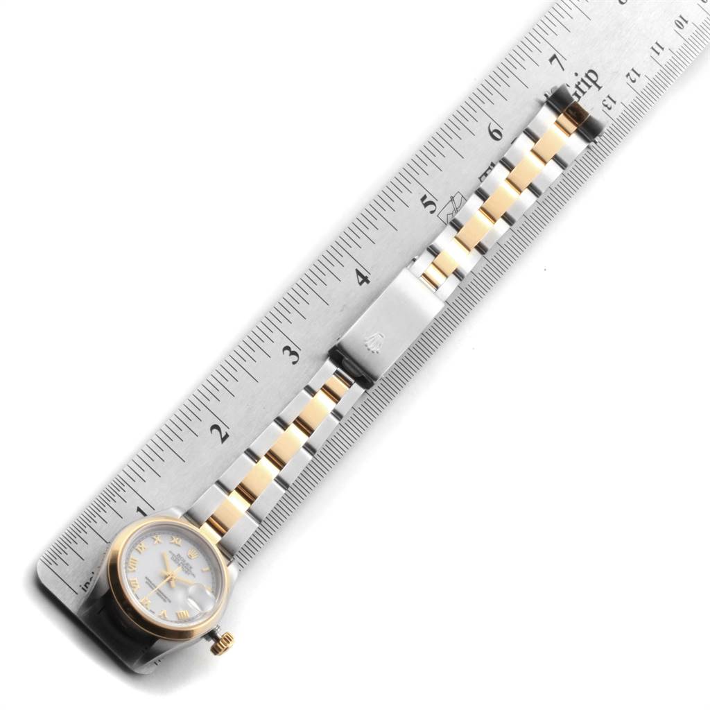 The image shows a top-down view of a Rolex Datejust 69163 Women's Steel and Gold (two tone) White Dial 69163 Women's Steel and Gold (two tone) White Dial watch, featuring its face, crown, and part of its metal bracelet beside a ruler.