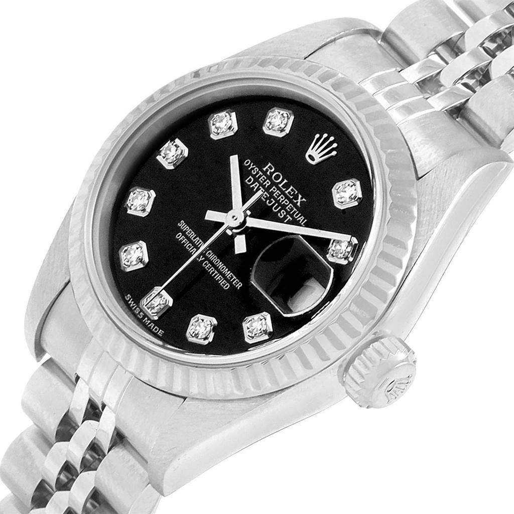 The image shows a close-up view of a Rolex Datejust 79174 Women
s Stainless Steel Black Dial 79174 Women
s Stainless Steel Black Dial watch, highlighting its dial, crown, and a section of its bracelet.