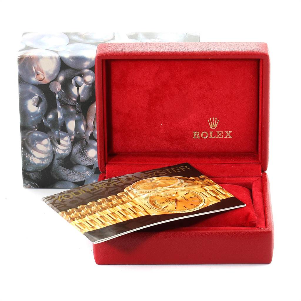 The image shows a red Rolex box for the Datejust model with a booklet partially covering the inside.