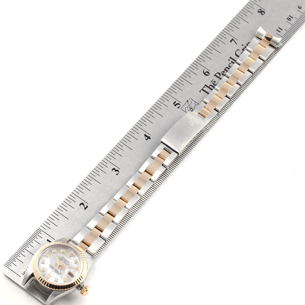 The image shows a Rolex Datejust 79173 Women's Stainless Steel Mother of Pearl Dial 79173 Women's Stainless Steel Mother of Pearl Dial watch laid flat alongside a ruler, showcasing its face and bracelet.
