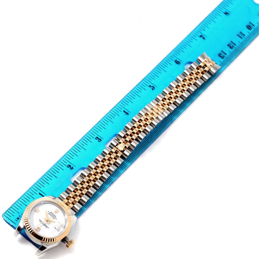 The image shows a Rolex Datejust 179173 Women's Steel and Gold (two tone) White Dial 179173 Women's Steel and Gold (two tone) White Dial watch laid flat next to a ruler, displaying its face and entire bracelet.