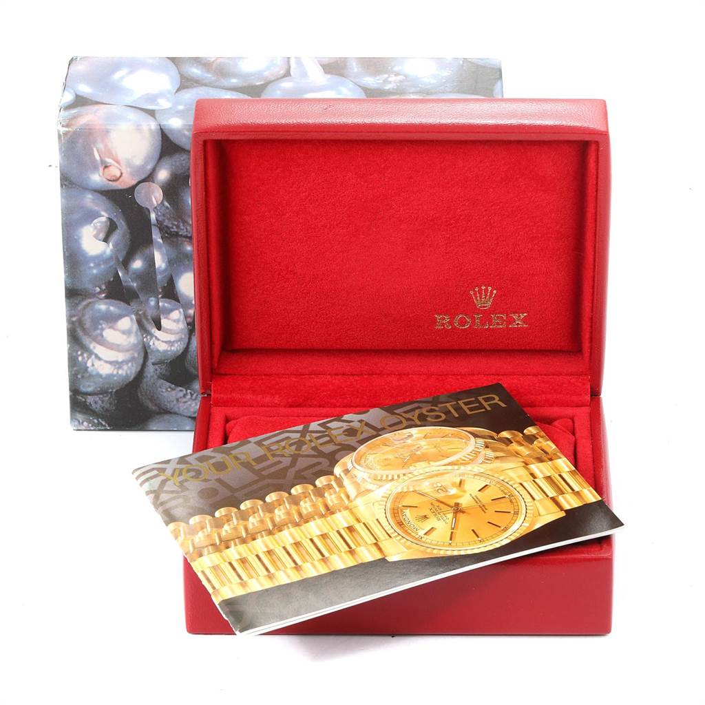 The image shows a red Rolex box for the Datejust model with a corresponding booklet placed in front of it.