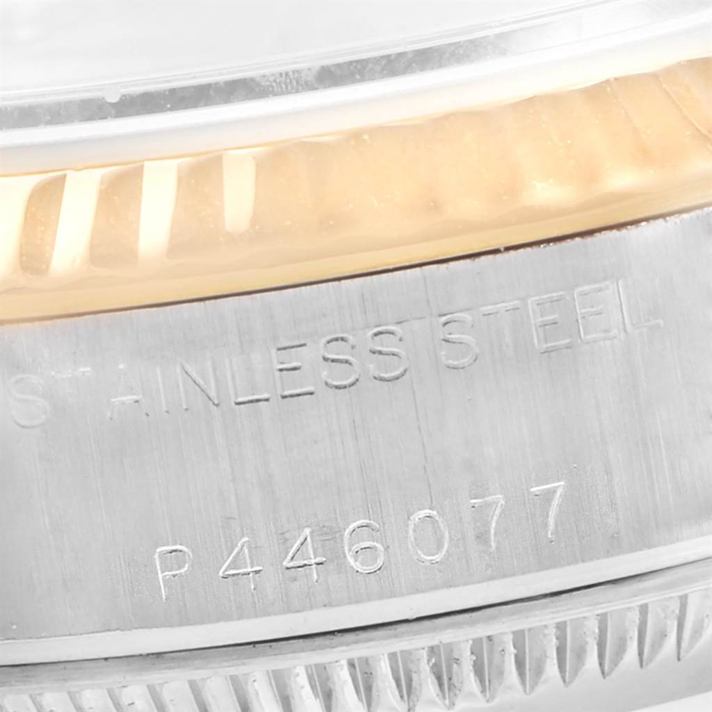 The image shows a close-up of the side engraving and part of the gold fluted bezel of a Rolex Datejust 79173 Women's Stainless Steel Silver Dial 79173 Women's Stainless Steel Silver Dial watch.