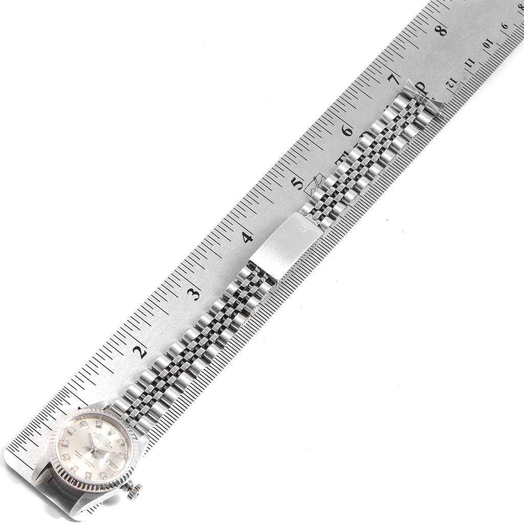 This image shows a Rolex Datejust 69174 Stainless Steel Silver Dial 69174 Stainless Steel Silver Dial watch laid next to a ruler, highlighting its band, clasp, and face from a top view.