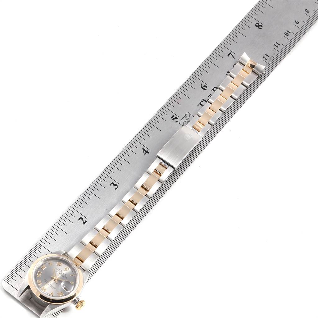 The image shows a Rolex Datejust 79163 Women's Steel and Gold (two tone) Grey Dial 79163 Women's Steel and Gold (two tone) Grey Dial watch laid flat on a metal ruler, displaying the dial, bezel, crown, and bracelet.