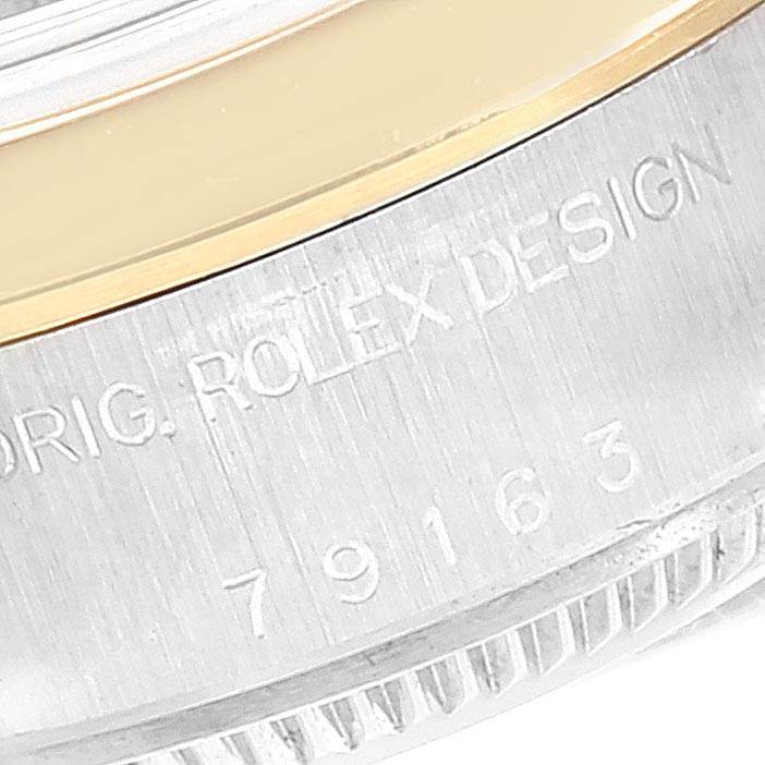 This close-up image of a Rolex Datejust 79163 Women's Steel and Gold (two tone) Grey Dial 79163 Women's Steel and Gold (two tone) Grey Dial shows part of the bezel and the engraved model number on the watch case.