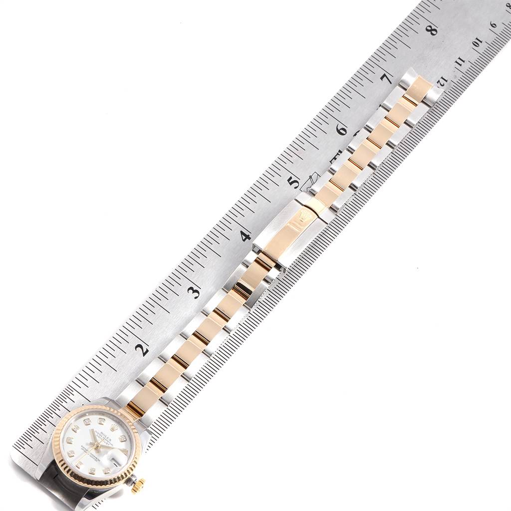The image shows a Rolex Datejust 179173 Women's Steel and Gold (two tone) White Dial 179173 Women's Steel and Gold (two tone) White Dial watch laid flat, focusing on the face and the bracelet's links, against a ruler for measurement.