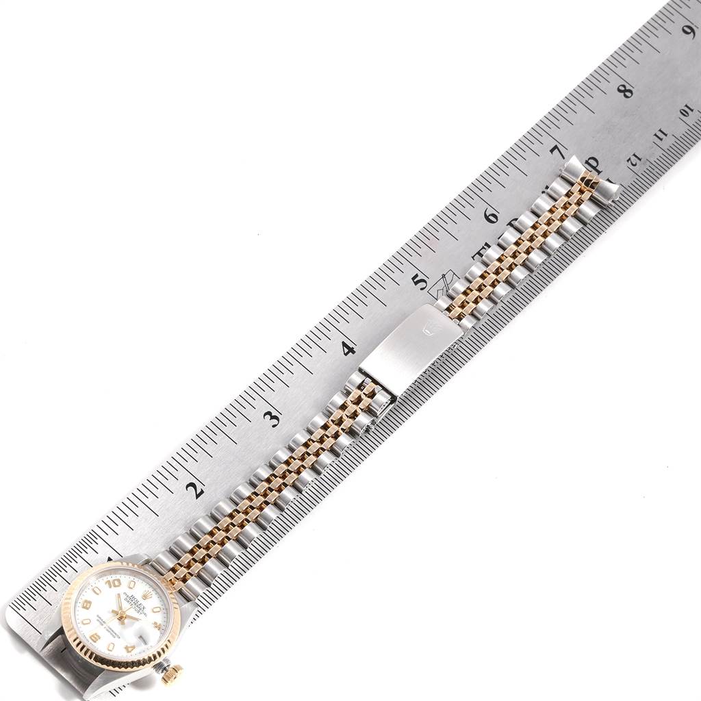 This image shows a Rolex Datejust 69173 Women's Stainless Steel White Dial 69173 Women's Stainless Steel White Dial watch placed next to a ruler, focusing on the face and bracelet at a top-down angle.