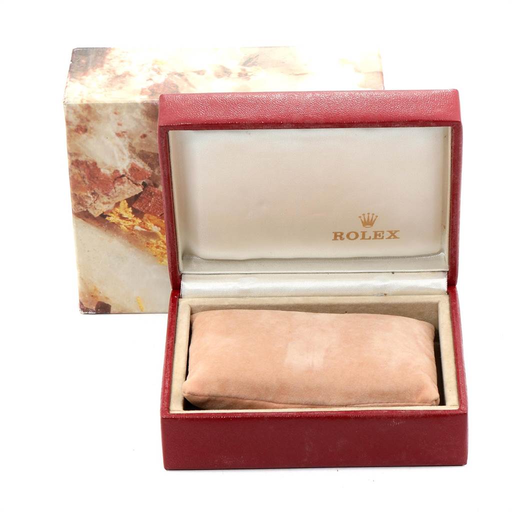 The image shows an open red Rolex box for a Datejust model watch, featuring a beige cushion inside.