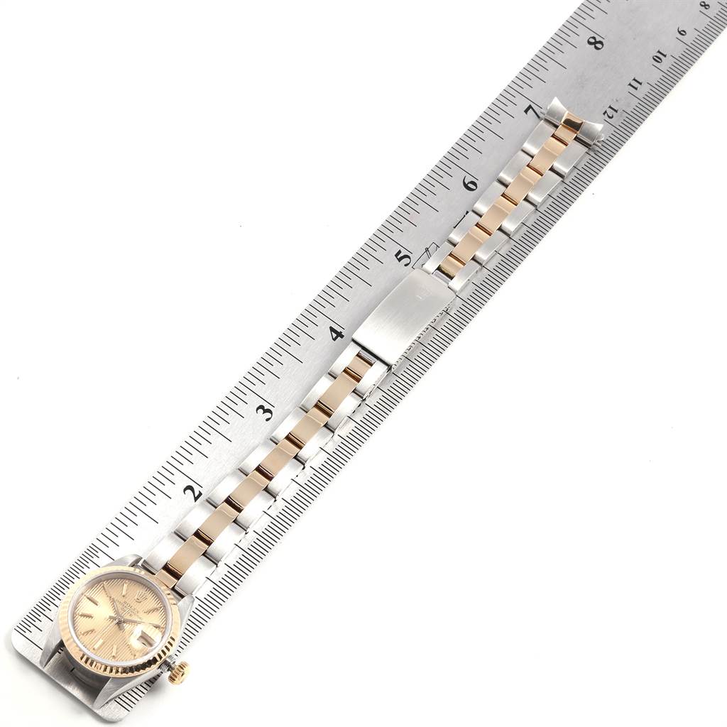 The image shows a Rolex Datejust 69173 Women
s Stainless Steel Champagne Dial 69173 Women
s Stainless Steel Champagne Dial watch with a two-tone bracelet, measured beside a ruler from an overhead angle.