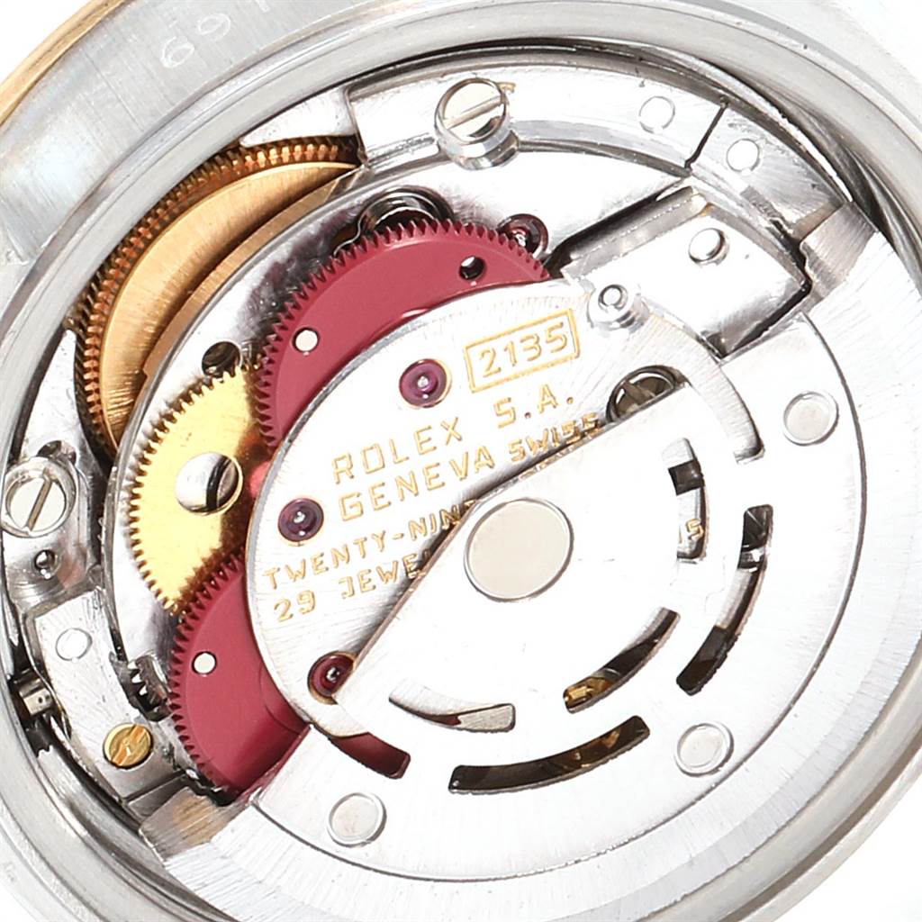 The image shows the intricate internal mechanism, including gears, of a Rolex Datejust 69173 Women
s Stainless Steel Champagne Dial 69173 Women
s Stainless Steel Champagne Dial watch from a close-up angle.