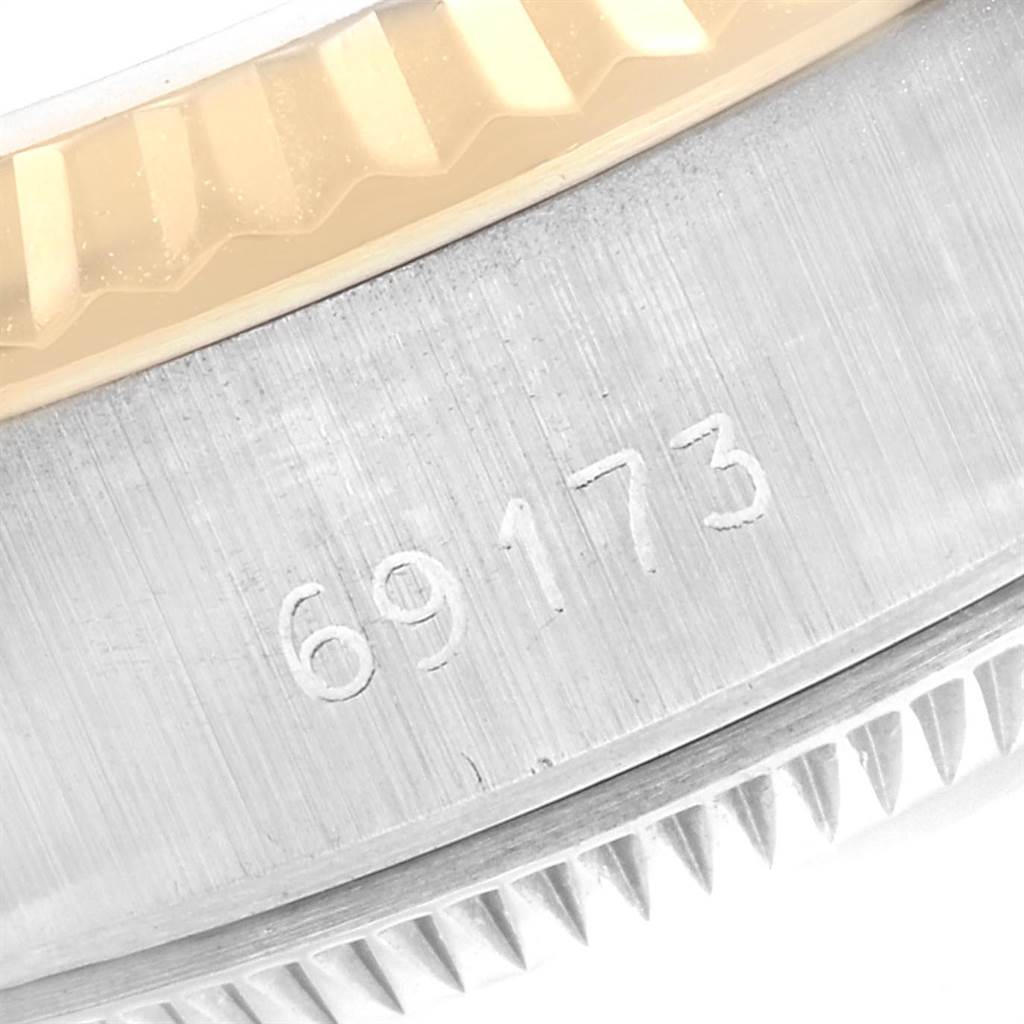 The image shows a detailed close-up of the model number on the side of a Rolex Datejust 69173 Women
s Stainless Steel Champagne Dial 69173 Women
s Stainless Steel Champagne Dial watch case, including its fluted bezel.