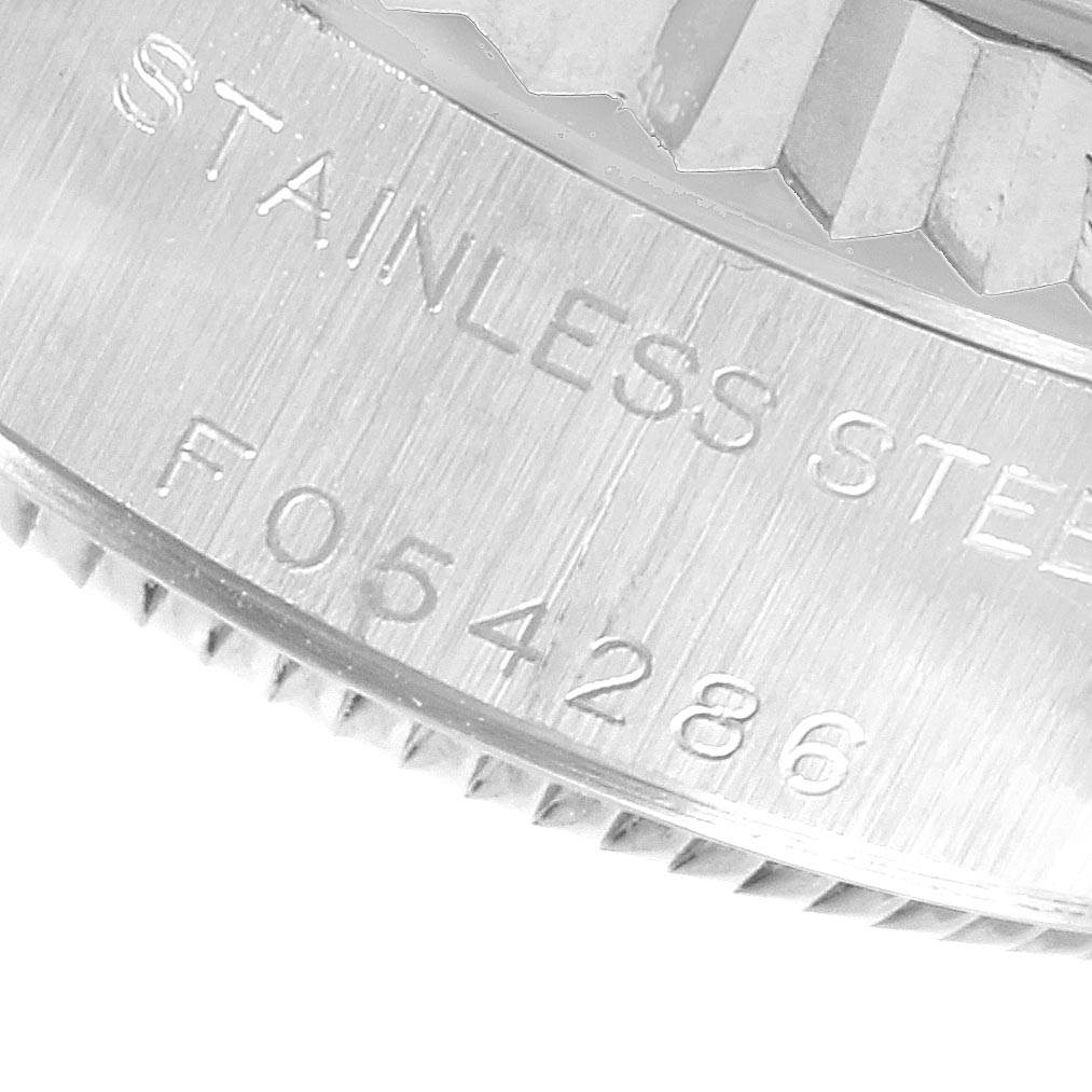 This image shows a close-up of the side of a Rolex Datejust 79174 Women's Stainless Steel Blue Dial 79174 Women's Stainless Steel Blue Dial watch, highlighting the serial number and "STAINLESS STEEL" engraving.