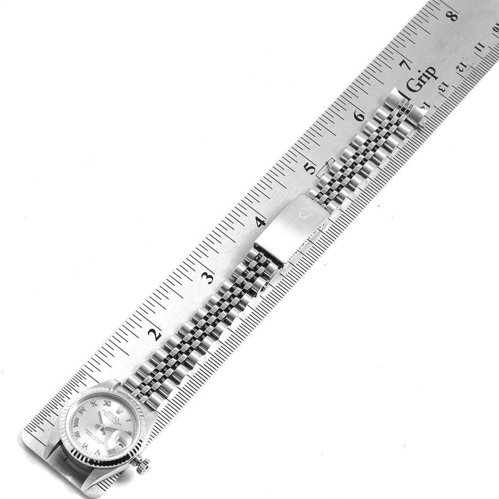 The image shows a top view of a Rolex Datejust 79174 Women
s Stainless Steel Silver Dial 79174 Women
s Stainless Steel Silver Dial watch with a ruler measuring its band length.