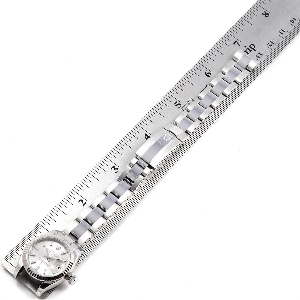 This image shows the Rolex Datejust 179174 Women
s Stainless Steel Silver Dial 179174 Women
s Stainless Steel Silver Dial watch from an overhead angle, including the dial and metal bracelet placed on a ruler.