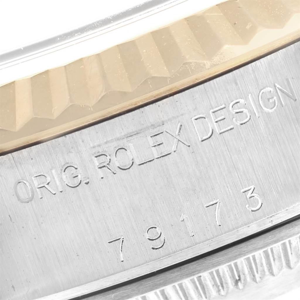 The image shows the side view of a Rolex Datejust 79173 Women
s Stainless Steel Black Dial 79173 Women
s Stainless Steel Black Dial model with the engraving "ORIG. ROLEX DESIGN" and a serial number.