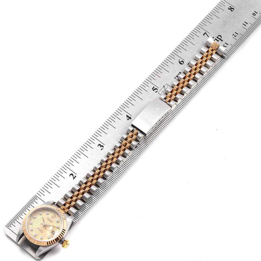 The image shows a Rolex Datejust 79173 Women's Stainless Steel Champagne Dial 79173 Women's Stainless Steel Champagne Dial watch laid flat against a ruler, displaying its face, crown, and metal bracelet.