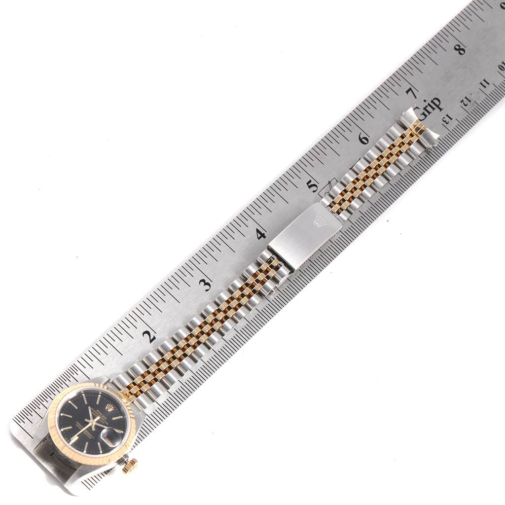 The Rolex Datejust 79173 Women's Steel and Gold (two tone) Black Dial 79173 Women's Steel and Gold (two tone) Black Dial watch is shown from a top-down angle, highlighting the face, bezel, and bracelet measured against a ruler.