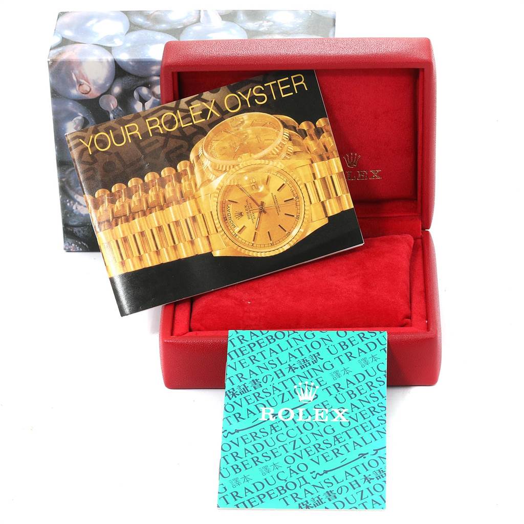 This image shows the accessories for a Rolex Datejust 79173 Women
s Steel and Gold (two tone) Blue Dial 79173 Women
s Steel and Gold (two tone) Blue Dial, including a booklet and translation book, placed inside an open red watch box.