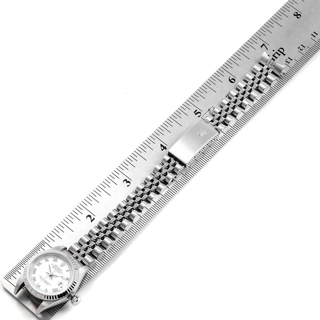The image shows a Rolex Datejust 79174 Women's Stainless Steel White Dial 79174 Women's Stainless Steel White Dial watch laid next to a ruler, displaying the watch face and metal bracelet.