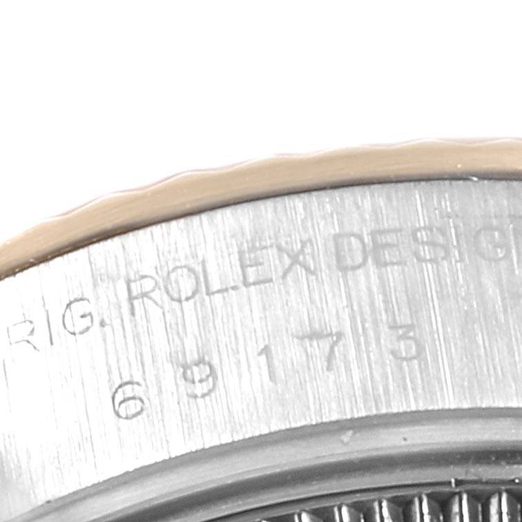 A partial close-up view of the bezel and engraving on the side of a Rolex Datejust 69173 Women's Stainless Steel White Dial 69173 Women's Stainless Steel White Dial watch.