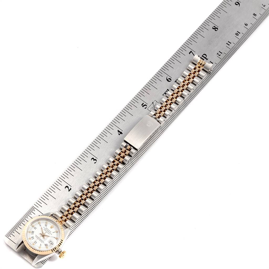 The image shows a Rolex Datejust 69173 Women's Stainless Steel White Dial 69173 Women's Stainless Steel White Dial watch laid flat with its metal and gold bracelet aligned with a ruler.