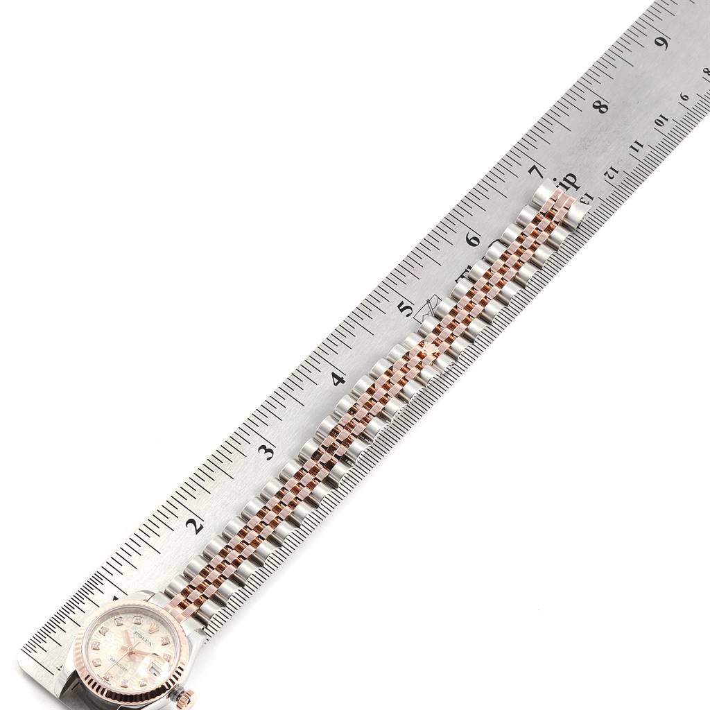 The image shows the Rolex Datejust 179171 Women's Steel and Gold (two tone) Silver Dial 179171 Women's Steel and Gold (two tone) Silver Dial watch face and band, with the band aligned next to a ruler for measurement.