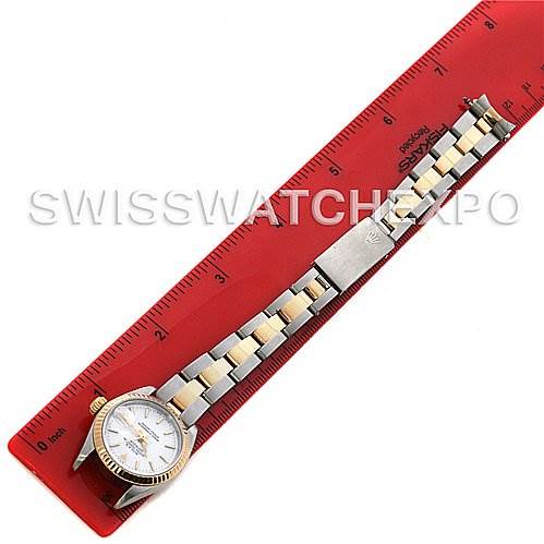 The image shows a Rolex Datejust 69173 Women's Stainless Steel  69173 Women's Stainless Steel  watch laying flat alongside a red ruler, showcasing its face and two-tone bracelet.